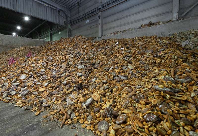 A large pile of discarded bread inside an industrial storage area in Ohio