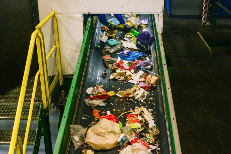 Mixed waste moving on a conveyor belt at a recycling facility