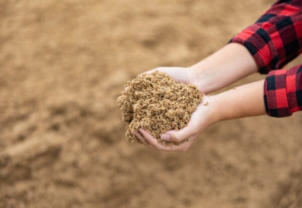 Hands holding processed spent grain material for food waste management